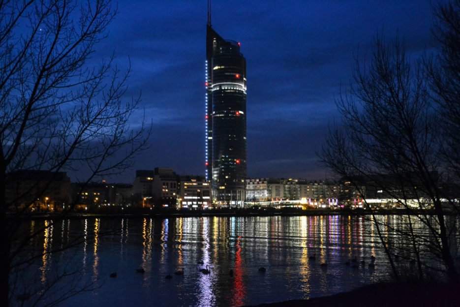 Nocne zdjęcie Millennium Tower w Wiedniu zrobione z Donauinsel
