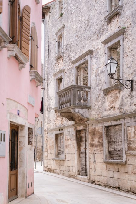 A narrow winding street and a stone old house in the town of Vodnjan, Istria, Croatia